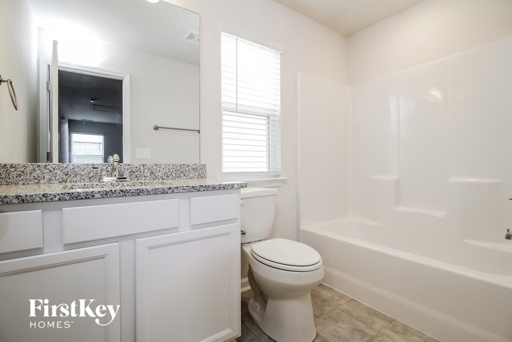 a white bathroom with a toilet and a tub and a sink