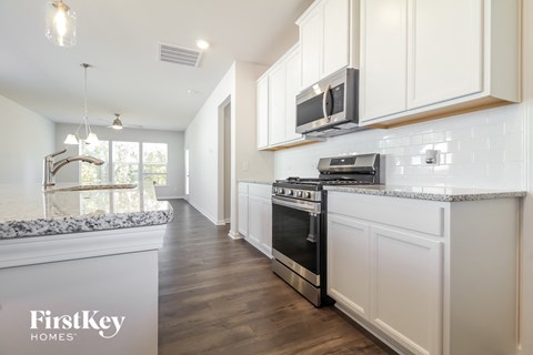 A kitchen with a stove top oven and a microwave above it.