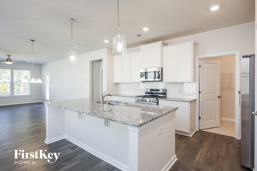 A kitchen with a granite countertop and white cabinets.