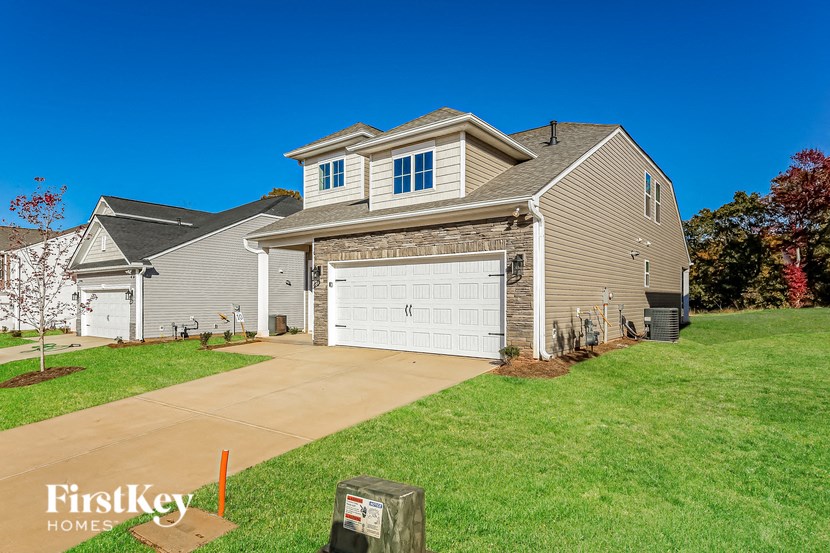 a house with a white garage door in front of a green lawn