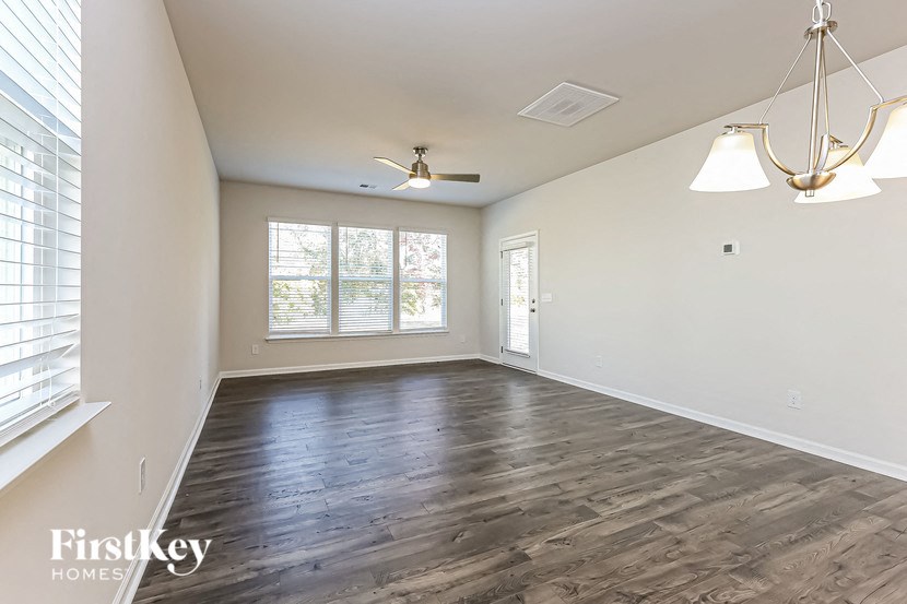 an empty living room with white walls and wood floors