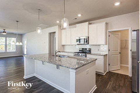 a kitchen with white cabinets and a marble counter top