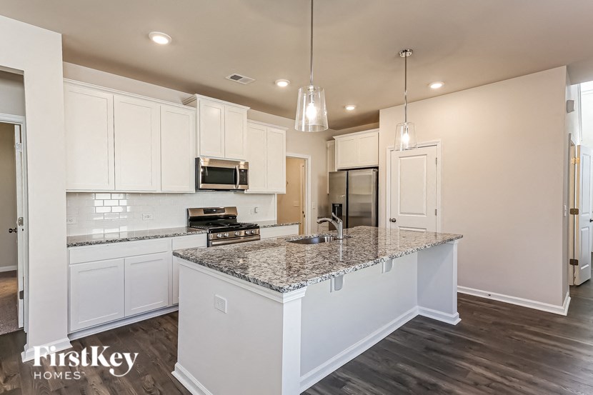a kitchen with white cabinets and granite counter tops