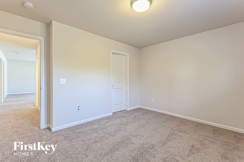 an empty living room with white walls and carpet