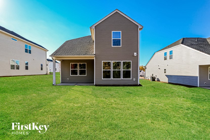 a house with a yard in front of two other houses
