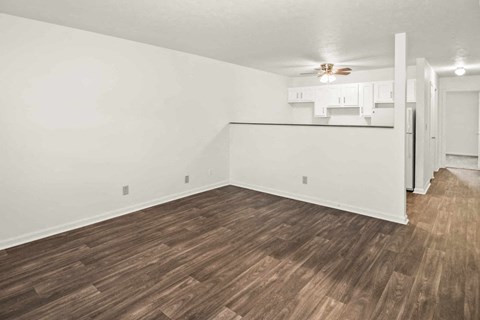 A room with wooden flooring and white walls.