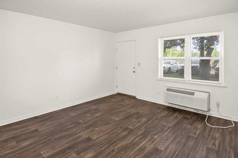 A room with a window and a wall-mounted air conditioner.