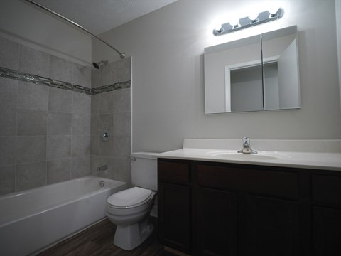 A white toilet sits next to a bathtub in a bathroom.