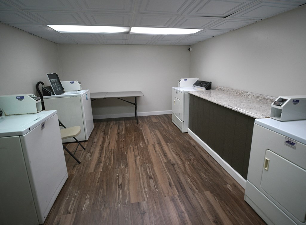 A medical office with a white examination table and a desk with a computer.