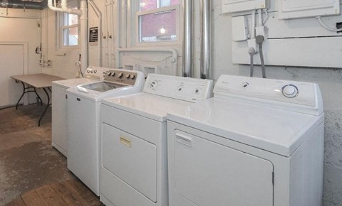 A pair of white front loading washing machines in a laundry room.