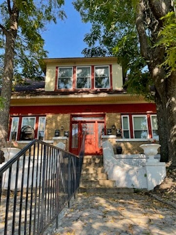 A house with a red door and a black fence.