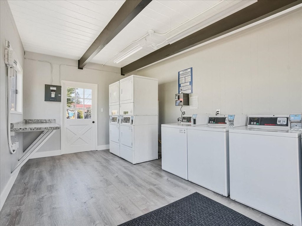 a kitchen with white appliances and a door to a laundry room