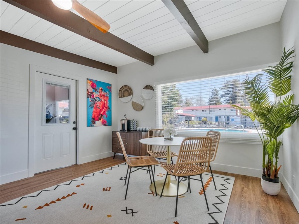 a dining room with a table and chairs and a large window