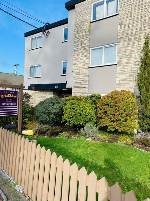 A McFarlane sign is in front of a grey building.