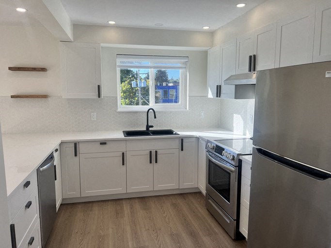 a kitchen with white cabinets and stainless steel appliances