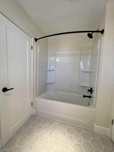 a bathroom with a shower and a tub and a door