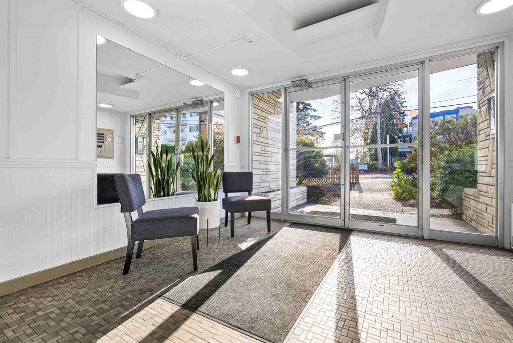 a lobby with chairs and a table and windows