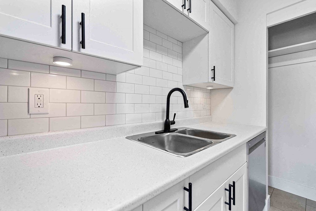 a kitchen with a sink and white cabinets