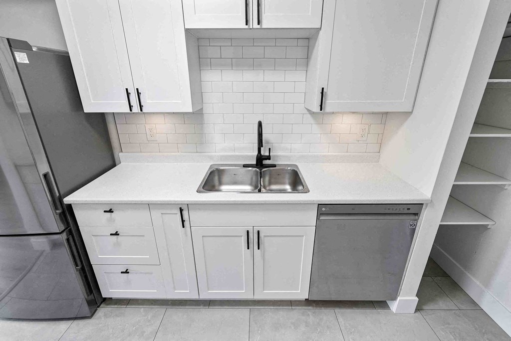 a small kitchen with white cabinets and a sink