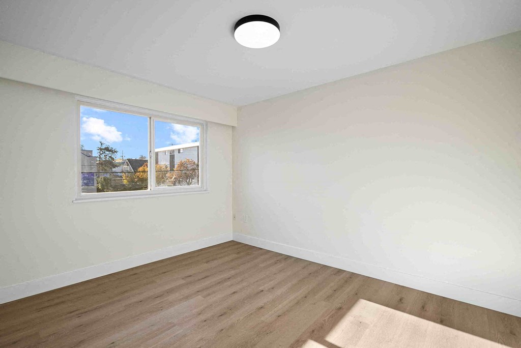 an empty room with white walls and a window