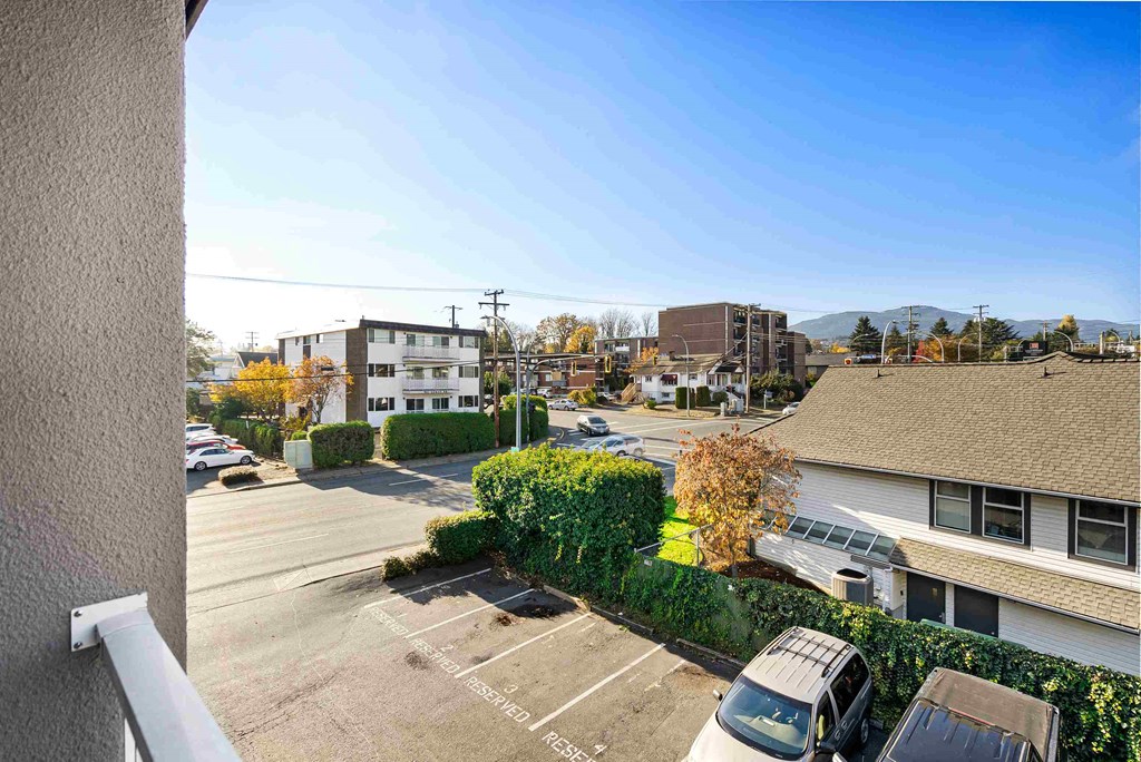 a view of a parking lot from a balcony of a apartment building