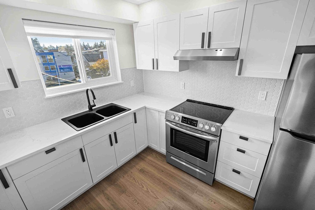 a kitchen with white cabinets and stainless steel appliances