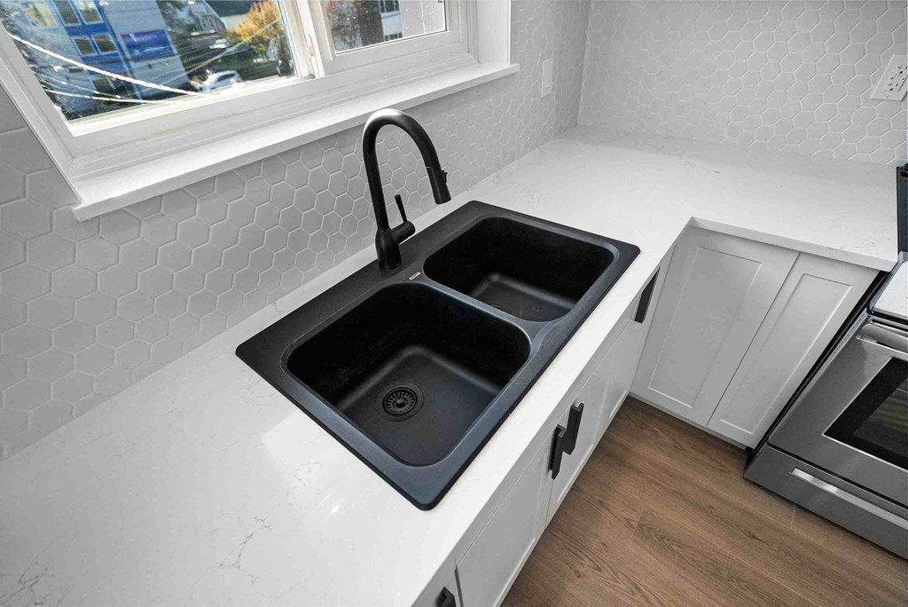 a kitchen with a stainless steel sink and a black faucet
