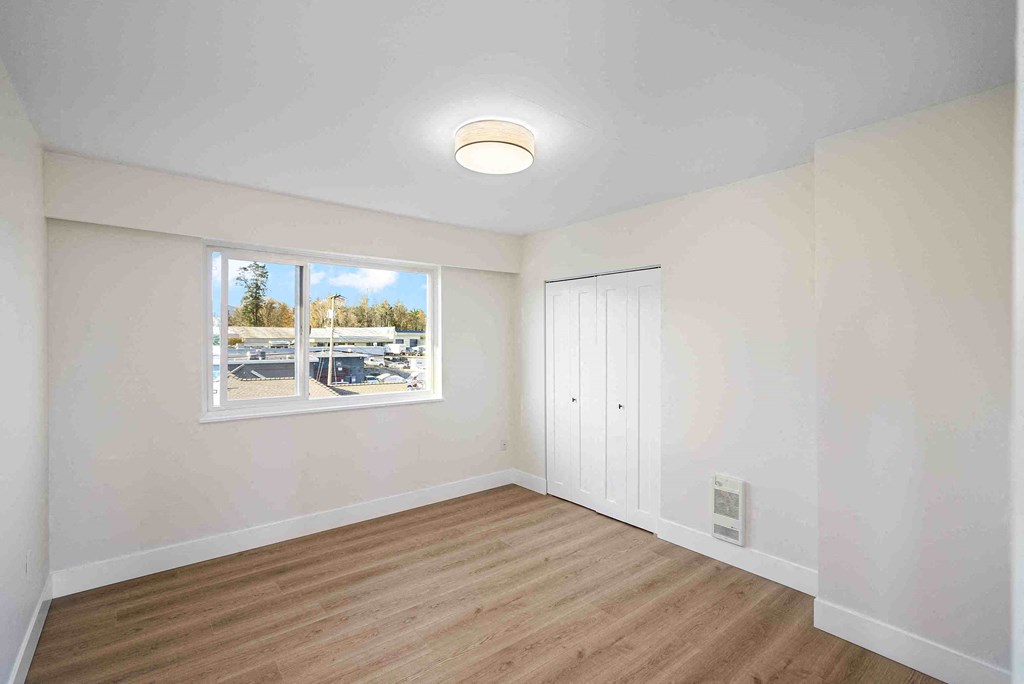 an empty room with white walls and a window