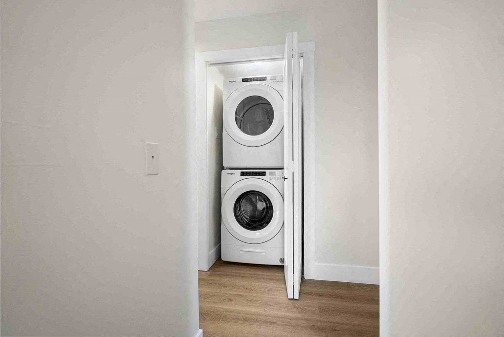a white washer and dryer in a white laundry room