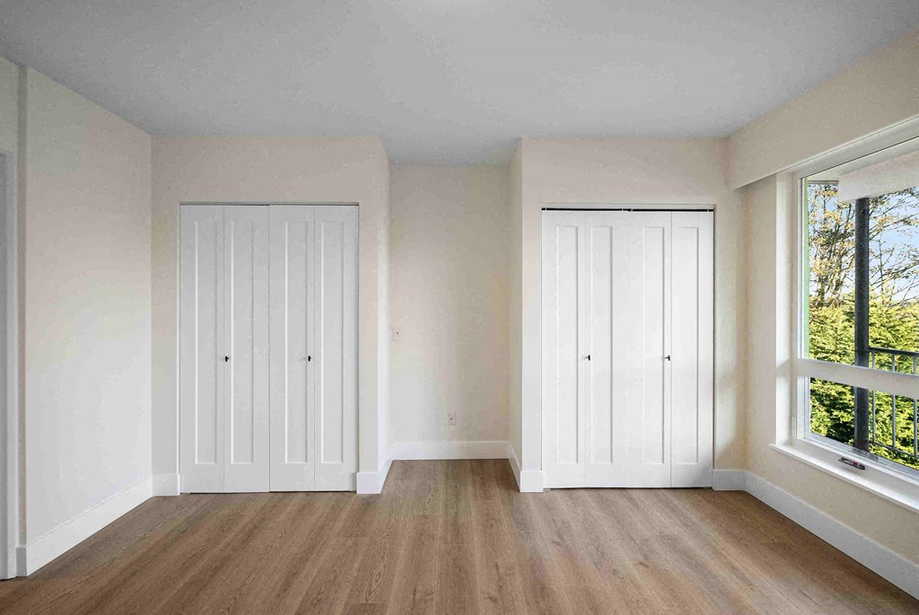 an empty room with white walls and a window and a door