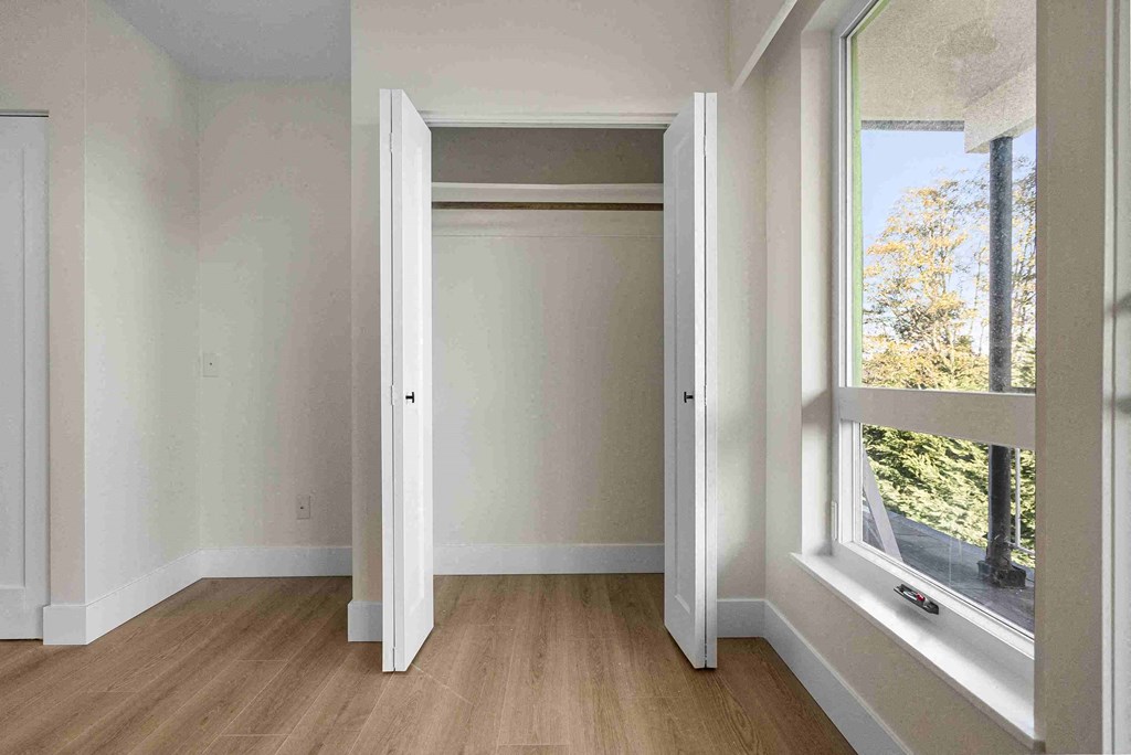 a living room with a large window and wooden floors