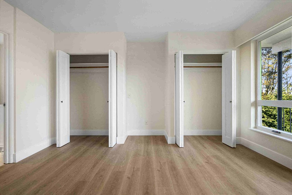 an empty living room with white walls and wood floors