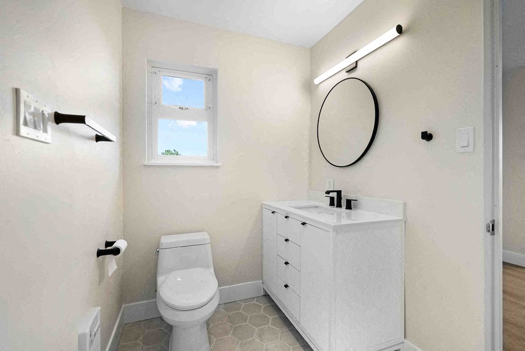a bathroom with a toilet and a sink and a mirror