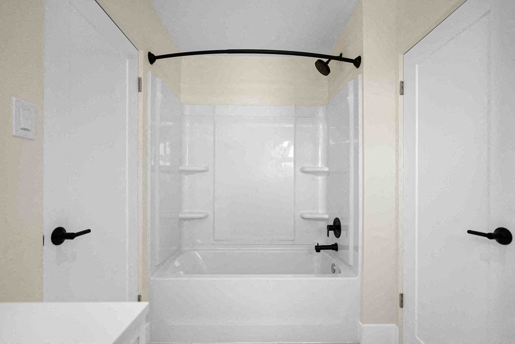 a white bathroom with a shower and a tub