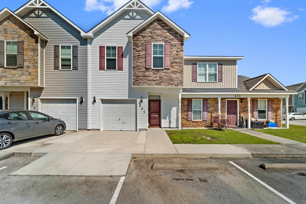 the front of a house with a car parked in the driveway