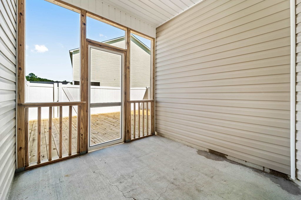 the patio of a house with glass doors and a deck