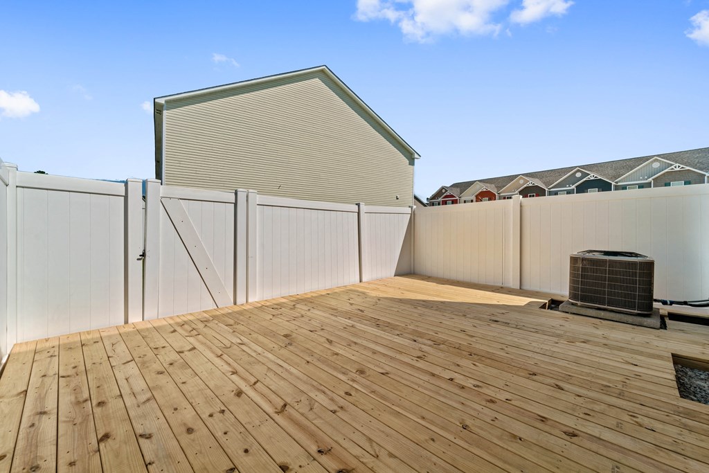 a backyard deck with a fence and a house