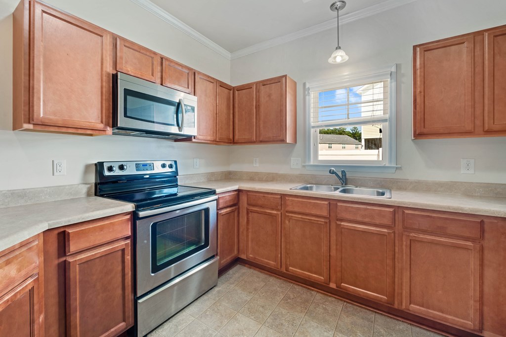 a kitchen with wooden cabinets and stainless steel appliances