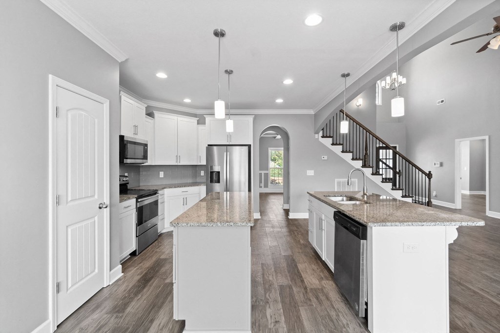an open kitchen with an island with granite counter tops