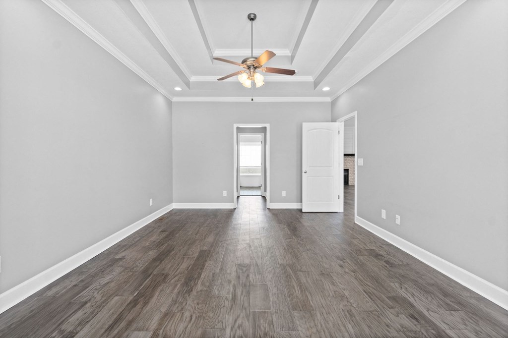 the living room of a new home with grey walls and a ceiling fan