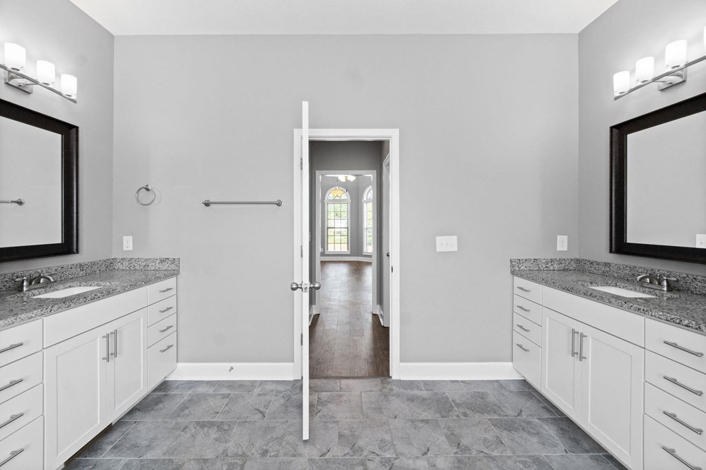 the master bathroom has dual sinks and a walk in shower