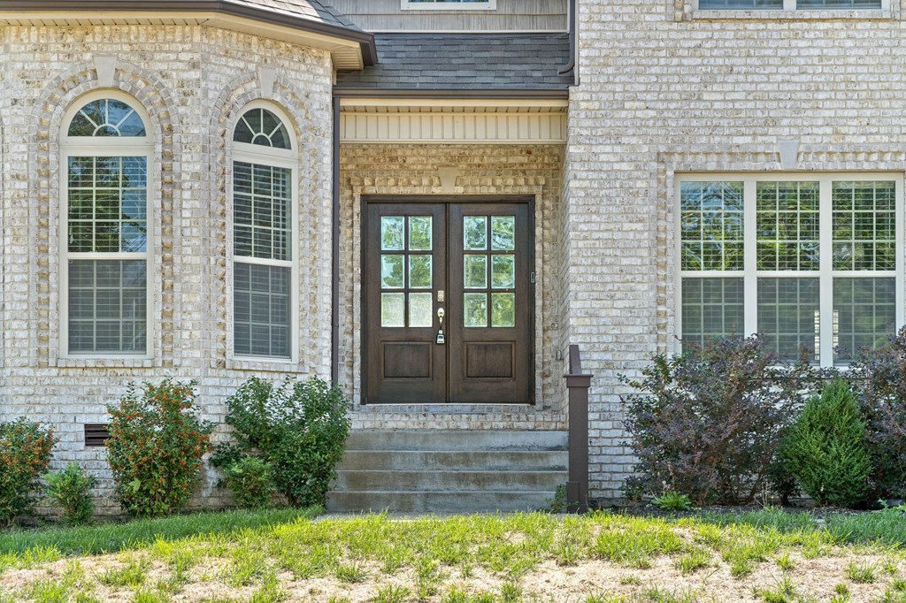 a home with a wooden door on a brick house