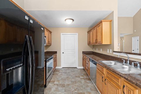 a kitchen with black appliances and wooden cabinets