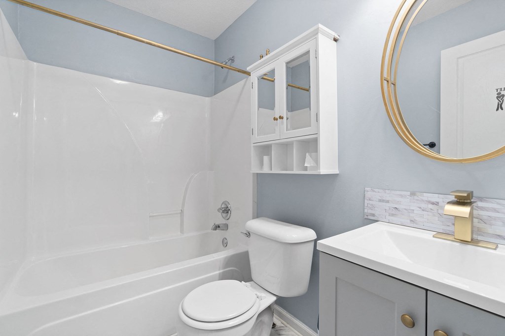 a bathroom with blue walls and a white toilet and tub
