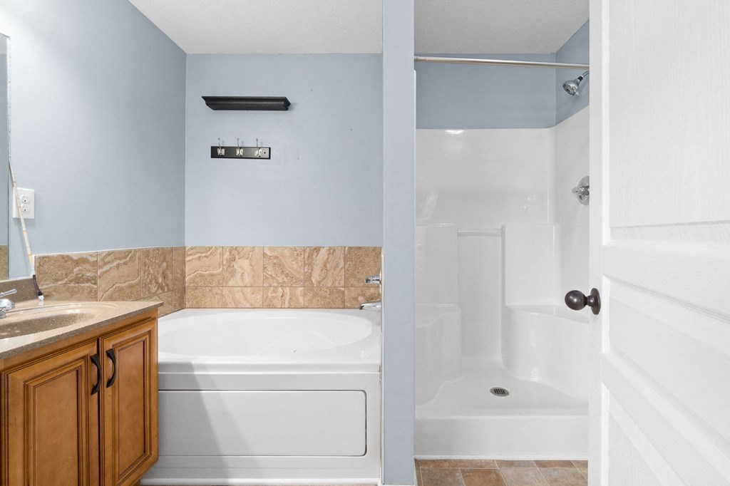 a bathroom with a tub and a shower and a sink