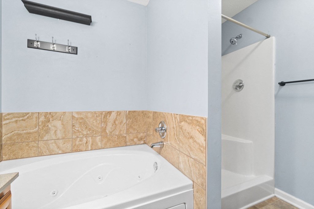 a bathroom with a tub and a shower and a sink