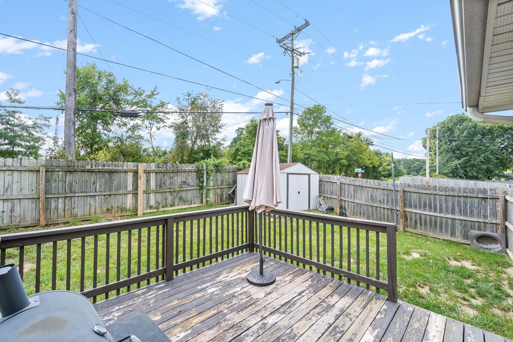 a backyard deck with an umbrella and a utility pole