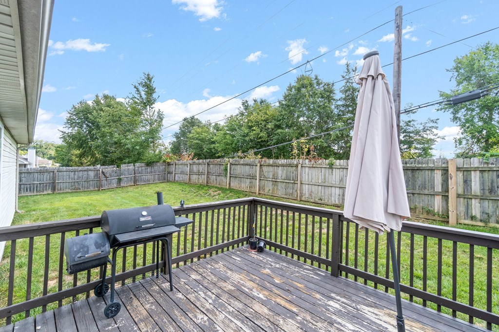 the back deck has a grill and an umbrella