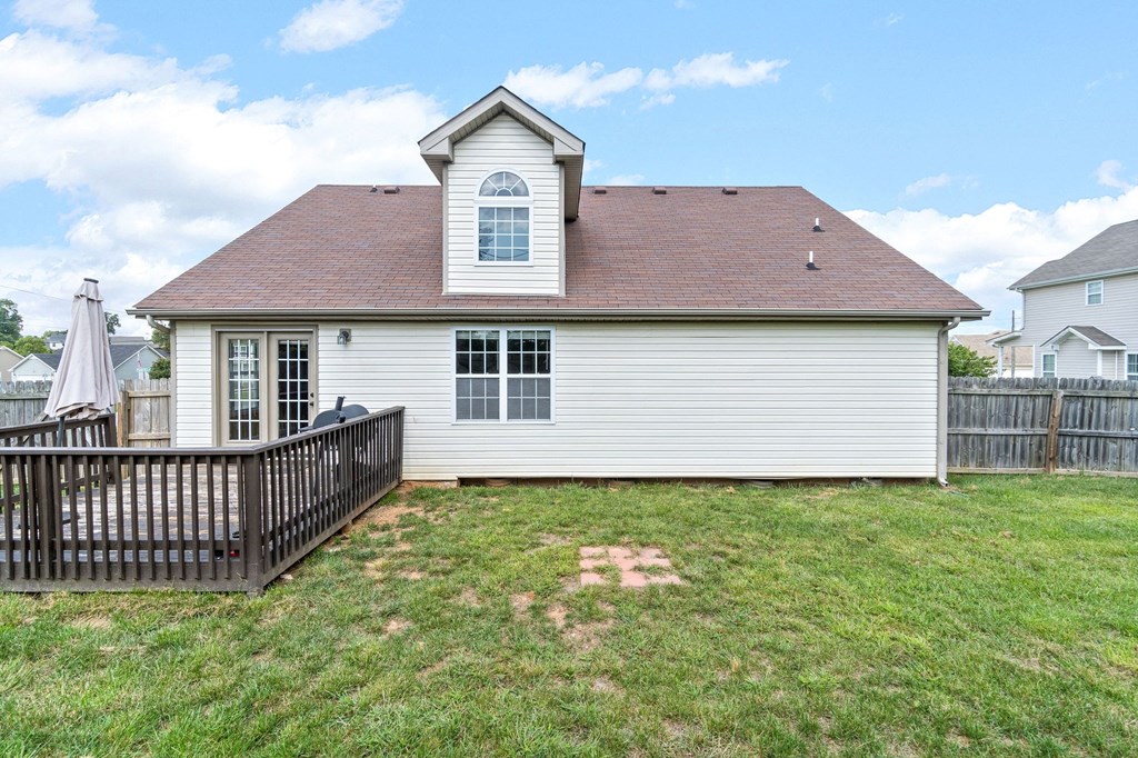 the back of a house with a yard and a fence