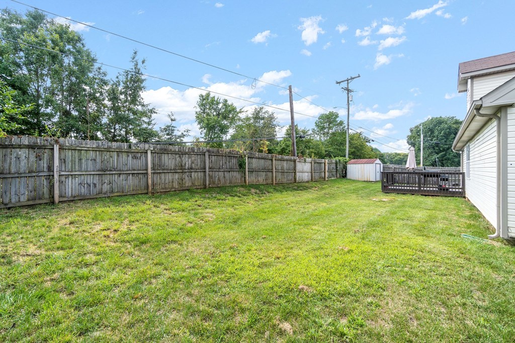 the backyard of a house with a fence and a green lawn